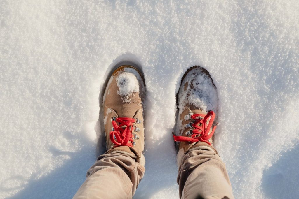 Jeune homme avec les pieds joints dans la neige