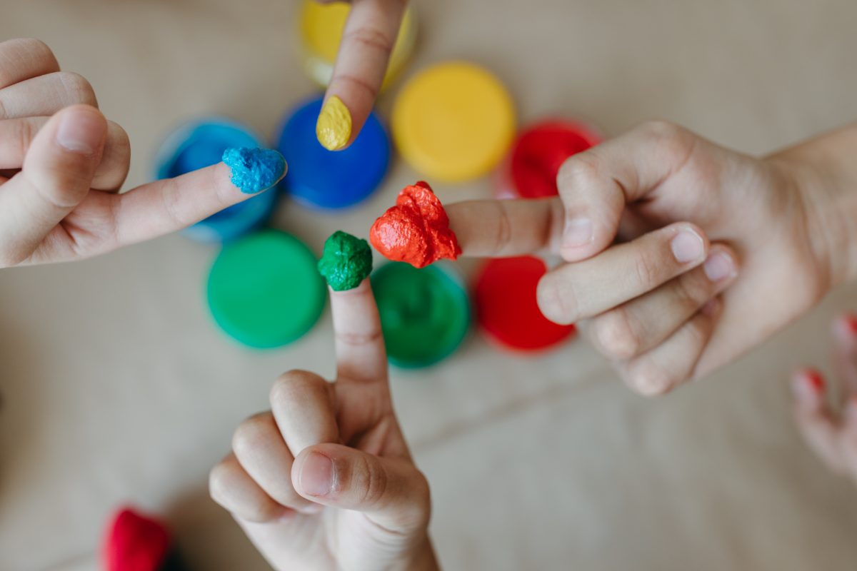 Enfants apprenant montessori avec peinture sur leurs doigts