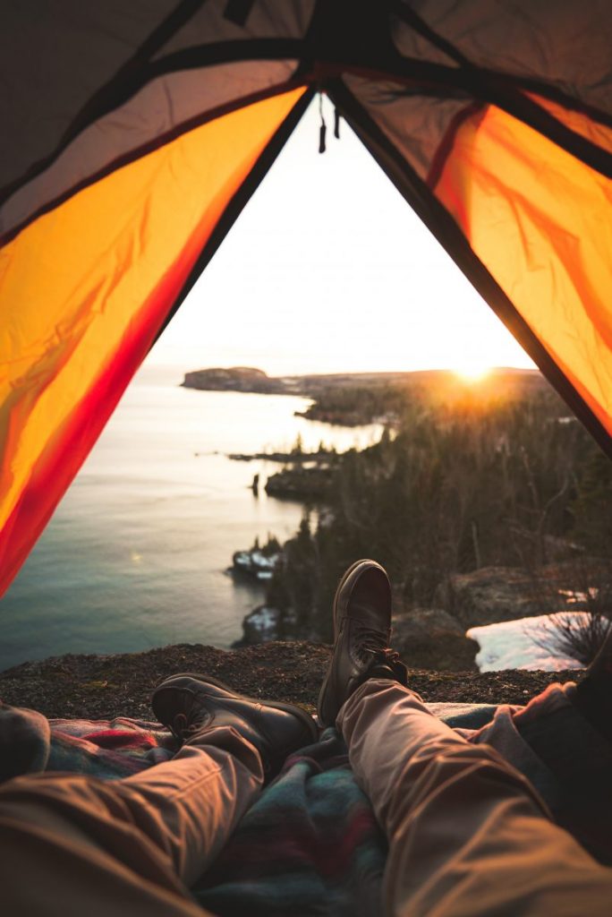 Jeune homme couché sous une tente de camping